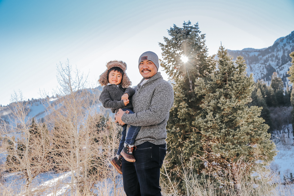 father and son smiling by mountains 