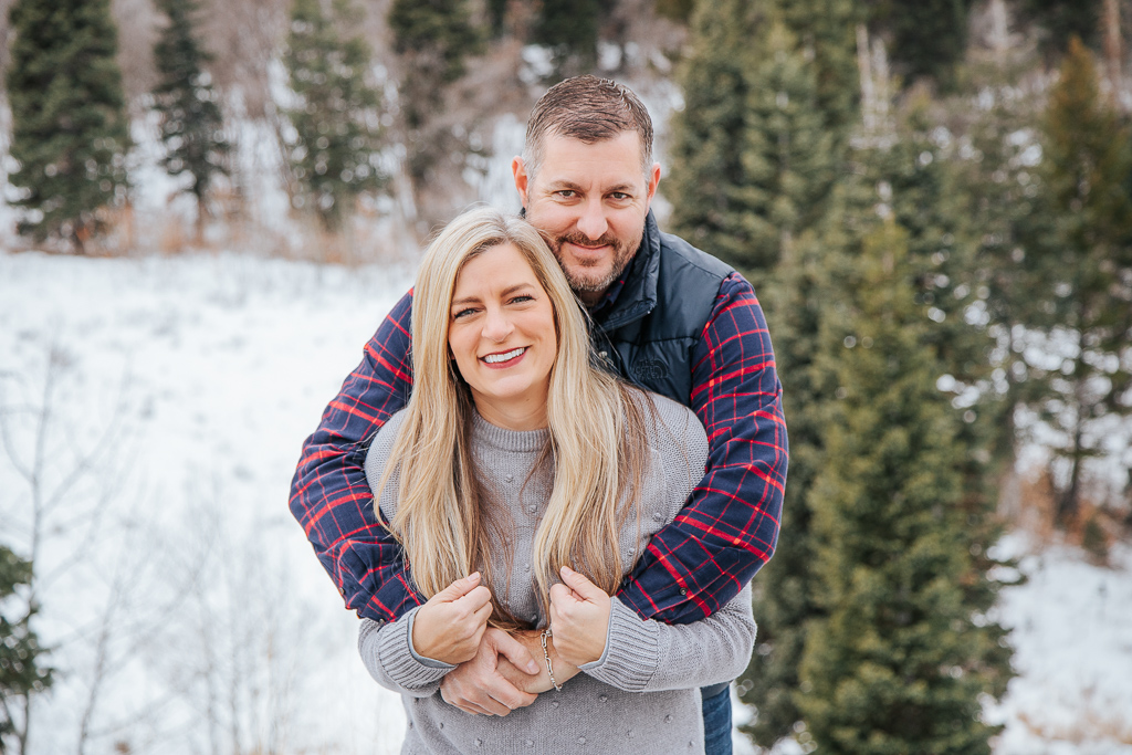 happy couple near pine trees